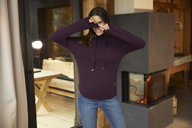 Aufnahme einer Frau in einem roten Merino Pullover.