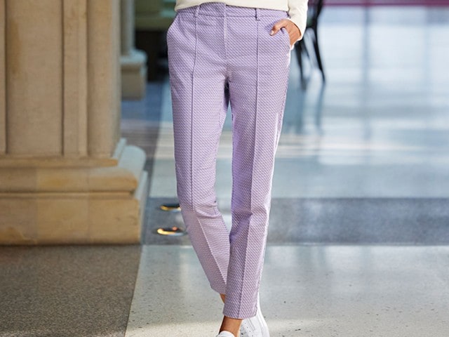 Frau trägt eine elegante 7/8 Hose in der Farbe Flieder.