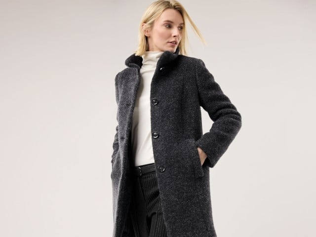 Eine Frau trägt einen Alpaka-Flausch-Kurzmantel in anthrazit, darunter einen Thermorolli in Weiß und dazu eine schwarze Marlenehose.