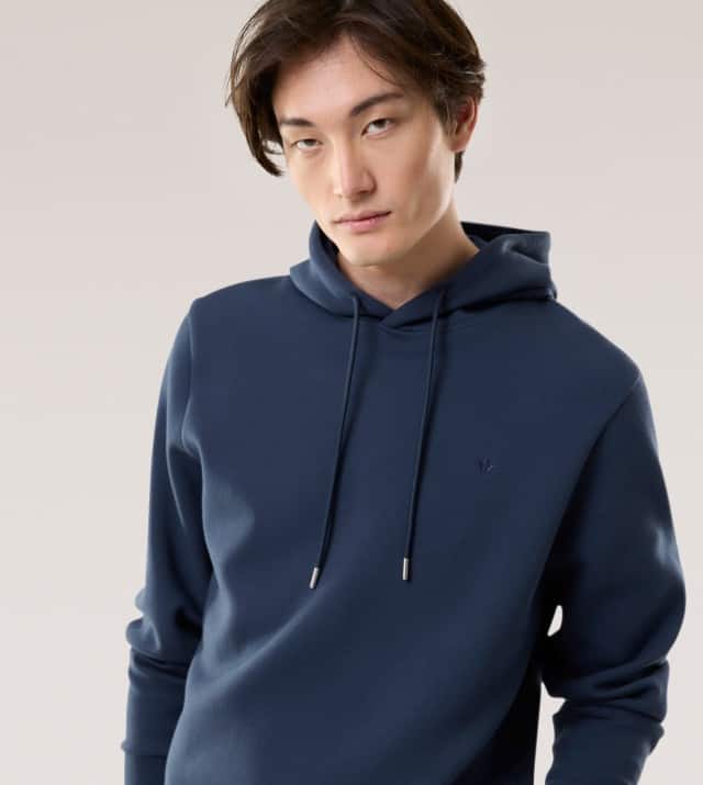 Ein Mann trägt einen Hoodie mit Walbusch-Logo in Marine.