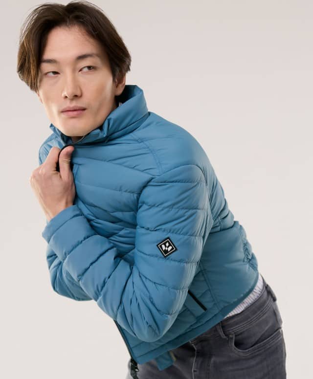 Ein Mann trägt eine Klima Leichtsteppjacke in Rauchblau.