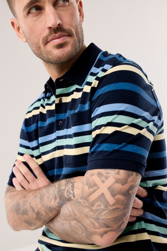 Ein Mann trägt ein gestreiftes Extraglatt-Polo Bicolor.