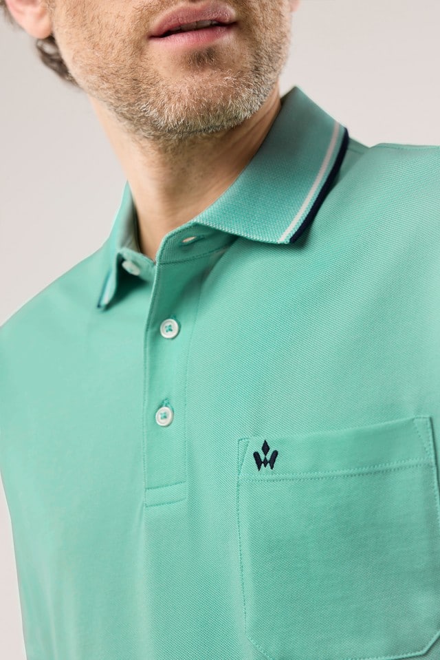Ein Mann trägt ein Extraglatt-Polo Bicolor in Uni-Mint.