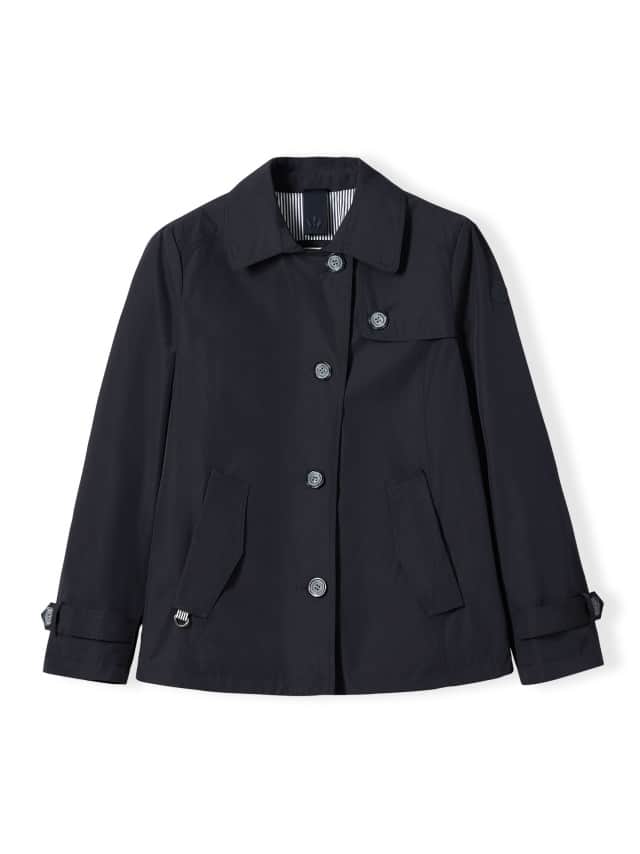 Eine dunkelblaue Jacke mit Knopfleiste, Kragen und zwei Fronttaschen liegt flach ausgebreitet vor weißem Hintergrund. Eine dunkelblaue Jacke mit Knopfleiste, Kragen und zwei Fronttaschen liegt flach ausgebreitet vor weißem Hintergrund.