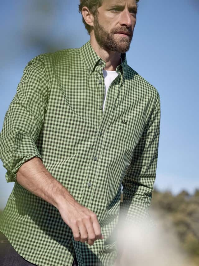 Ein Mann trägt ein Soft-Cotton Hemd in Vichy Oliv, darunter ein weißes Shirt.