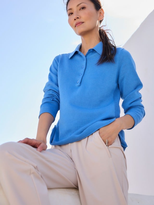 Eine Frau trägt einen leuchtend blauen Pullover zu einer hellen, locker fallenden Hose, was frisch, modern und entspannt wirkt. Eine Frau trägt einen leuchtend blauen Pullover zu einer hellen, locker fallenden Hose, was frisch, modern und entspannt wirkt.