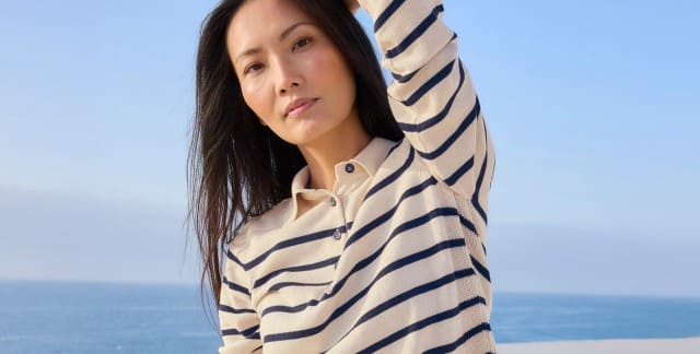 Ein Frau steht am Meer und trägt einen gestreiften Polo-Pullover. Ein Frau steht am Meer und trägt einen gestreiften Polo-Pullover.