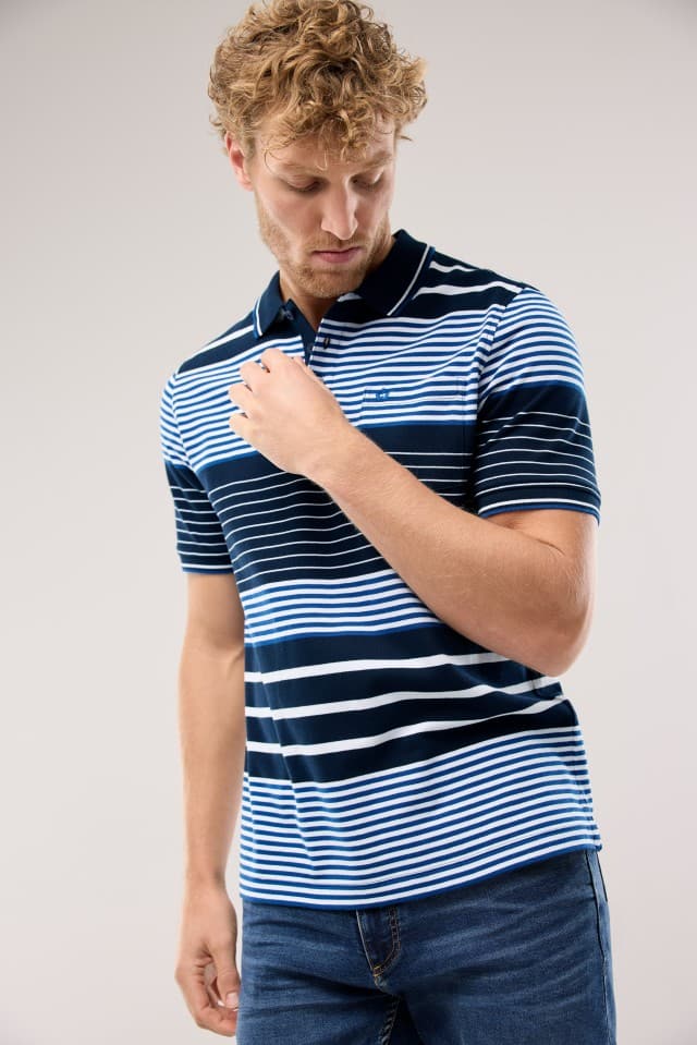Ein Mann trägt ein Pique-Polo Hitzefrei in Streifen Marine dazu eine Jeans.