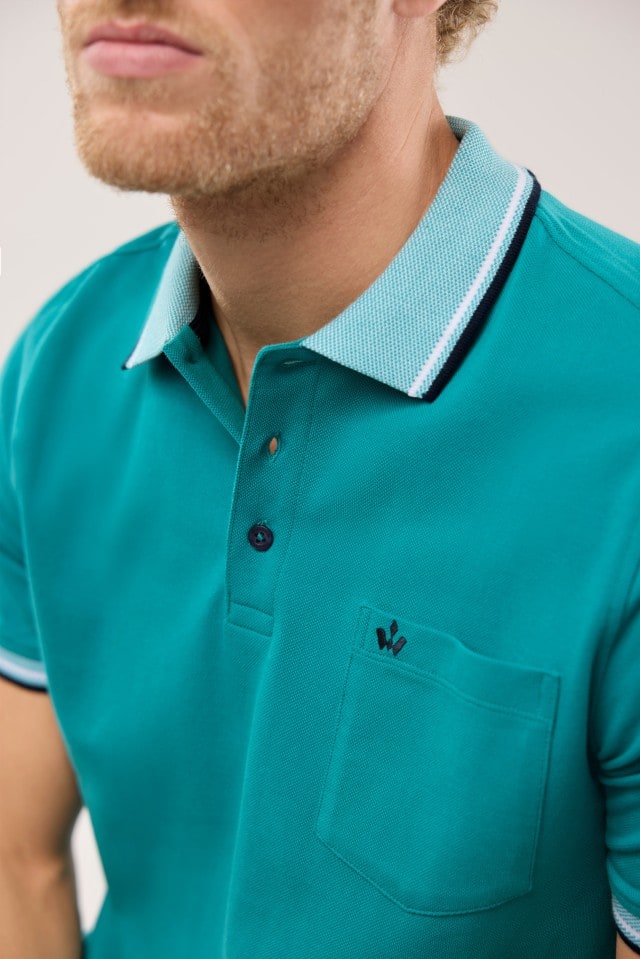 Ein Mann trägt ein Pique-Polo Hitzefrei in Uni Aqua.