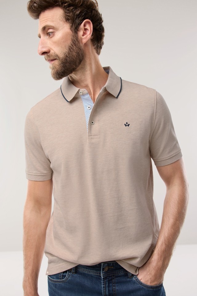 Ein Mann trägt ein Polo-Shirt in der Farbe Natur, dazu eine Jeans. Ein Mann trägt ein Polo-Shirt in der Farbe Natur, dazu eine Jeans.