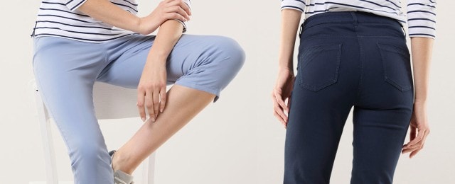 Zwei Frauen tragen moderne, körperbetonte Hosen in Hellblau und Dunkelblau, kombiniert mit weiß-blau gestreiften Oberteilen. Die Outfits wirken lässig-maritim und eignen sich ideal für einen entspannten Alltagslook.