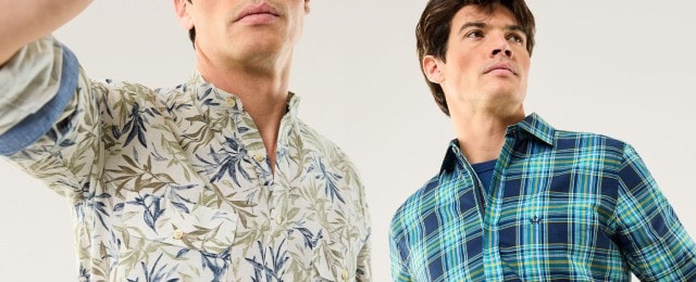 Ein Mann trägt ein helles Hemd mit Blätter-Print, daneben ist ein weiteres Hemd mit blau-grünem Karomuster zu sehen. Die Outfits wirken frisch, sommerlich und modisch.