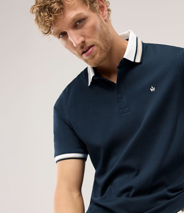 Ein Mann trägt ein Polo-Shirt in Marine. 