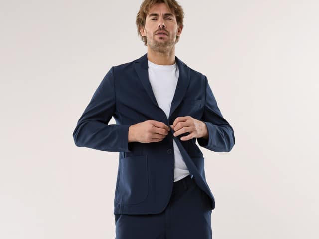 Ein Mann trägt einen Anzug in Marine mit einem weißen Shirt.