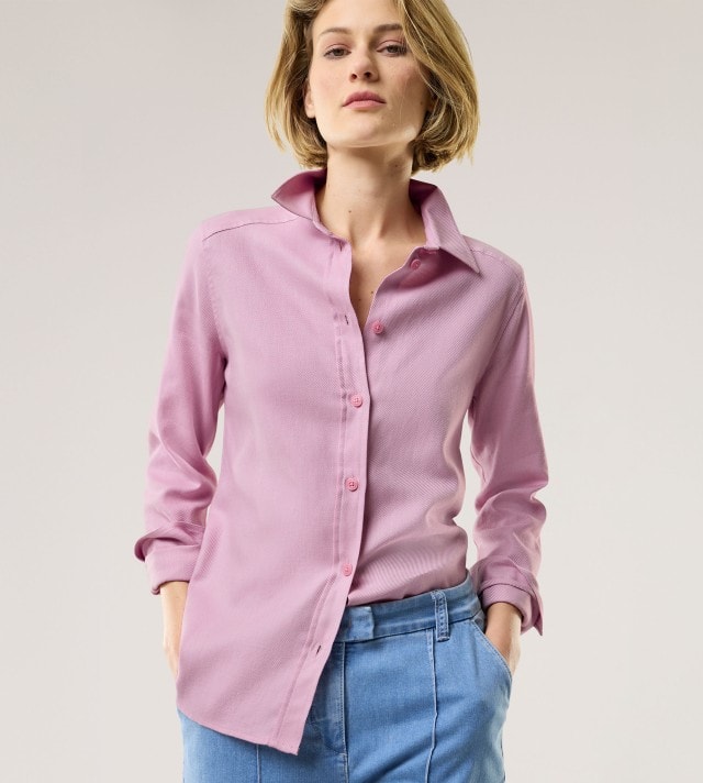 Eine Frau trägt eine Aktiv Flanell Hemdbluse in Altrosa, dazu eine Marlene Hose in Blau.