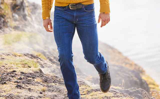 Mann trägt eine dunkelblaue Jeans im Gebirge