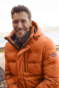 Ein Mann trägt eine Winterjacke in Orange.