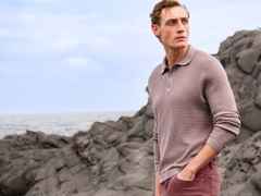 Eine Person trägt ein strukturiertes, mauvefarbenes Poloshirt mit langen Ärmeln und eine passende Hose. Der Stil ist lässig, modern und farblich harmonisch.